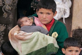 Syrian refugee children in Turkey making clothes for UK