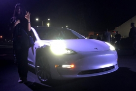 Musk hands over first Tesla Model 3 electric cars to early buyers