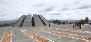 Волонтеры собирают цветы и венки, поднесенные к мемориальному комплексу Геноцида армян