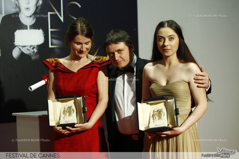 Romanian director Cristian Mungiu (C) with Best actresses Cristina Flutur (L) and Cosmina Stratan after being awarded with the Best Screenplay award for his film 
