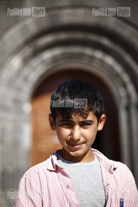 A boy earning money arranging shoes of prayers left at mosque entrance