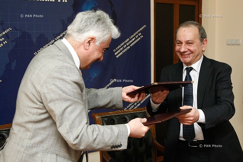 RA Minister of Economy Vahram Avanesyan and AJA vice president Artak Udumyan sign a contract