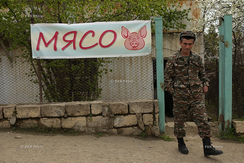 A soldier in front of a grocery store near Hadrut military unit