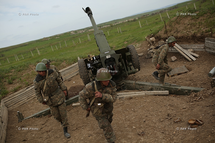 Artillerymen running towards a hideout before firing from a D-30 howitzer in the southeastern section of the Nagorno Karabakh-Azerbaijan contact line