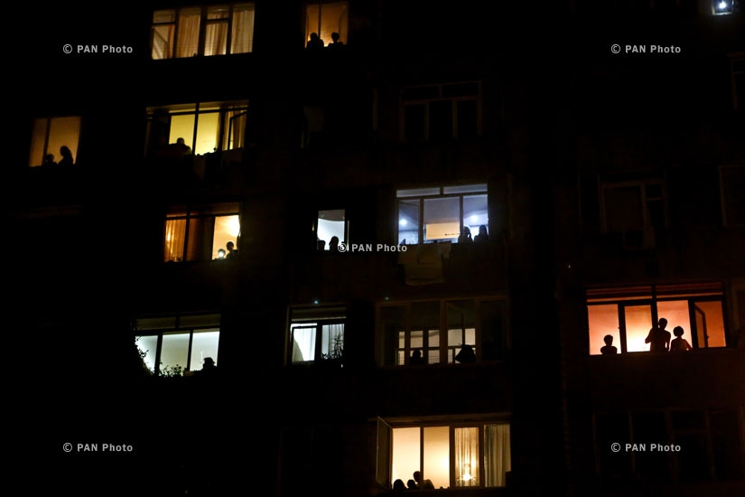 Жители окрестных домов наблюдают за шествием по улицам Еревана.